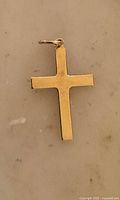 Front view of yellow gold cross pendant showing size and finish