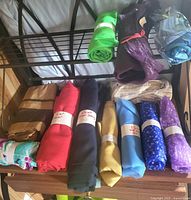 Full view of rack with multiple fabric rolls arranged on two levels