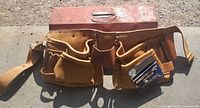 Closed red toolbox and carpenter belt front view