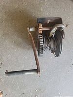 Winch showing crank handle, gear, cable on drum, mounting plate