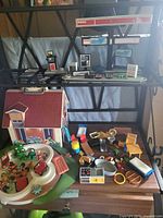 Overall view of dollhouse, figures, accessories, and Esso station parts on shelving