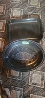Shows both rectangular and oval black speckled enamel roasting pans