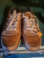 Top view of brown Skechers lace-up shoes showing design, laces, stitching, and overall condition