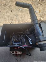 Sump pump in bin with discharge pipe and wiring