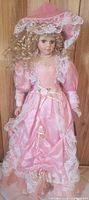 Front view of 27" porcelain doll in pink lace gown and hat