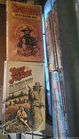Rack view showing Seven Wagons West and Ruff Justice covers plus spines of additional western paperbacks