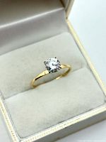 Ring in open box showing cubic zirconia and gold band