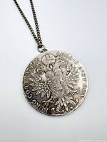 Front view of coin pendant on chain showing Imperial eagle reverse