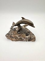 Front view of bronze dolphin on marble base