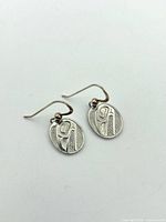 Front view of both oval sterling earrings showing carved design and ear wires