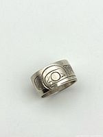 Front view of sterling silver ring showing Coast Salish eye motif and cross-hatch pattern