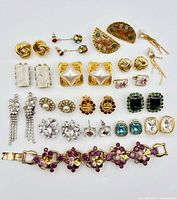 Full layout of 14 earring pairs and rhinestone bracelet