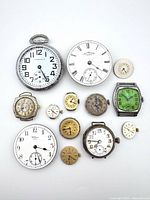 Group shot of all pocket watches, movements and Elgin wristwatch