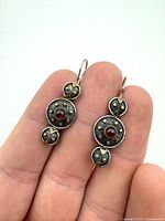 Front view of both sterling silver dangle earrings showing garnet cabochons and gold accents