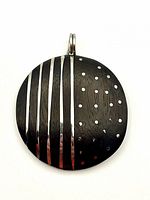 Front view showing silver stripe and dot inlay on dark wood pendant