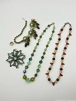 Full view of five jewelry pieces arranged on white background