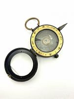 Compass open showing dial, sighting arm, lid interior