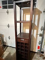 Full front view of espresso wood wine tower showing height, shelving, bottle grid, stemware rack