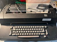Front view of IBM Correcting Selectric II typewriter showing keyboard and manual behind paper rest