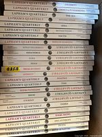 Stack of twenty-five Lapham’s Quarterly issues showing spines with multiple topic titles