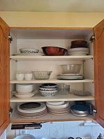 Cabinet shelves showing majority of plates and bowls