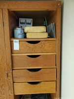 Wooden shelf with drawers holding sponges, Player’s tin, showing lot context