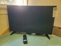 Front view of Insignia 24-inch Fire TV on stand with remote