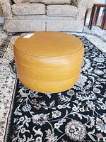 Full view of mustard round ottoman on rug