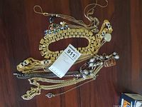 Group view of mixed jewelry pieces showing collar necklace, chains, bead strand, carved wood pendant