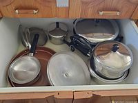 Drawer with multiple pans, pots, lids