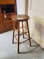 Full view of stool showing round seat, legs and overall height