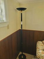 Full view of black torchiere floor lamp in corner showing height and style