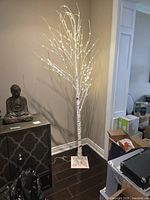 Full view of 8-ft white birch LED tree standing on floor, lights on