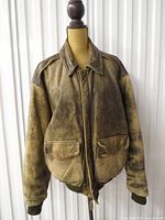 Front view zipped showing distressed leather, flap pockets, knit cuffs/hem