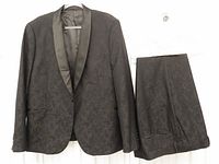 Suit jacket and trousers hanging, full view
