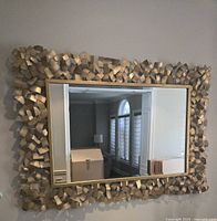 Front view of rectangular mirror with sculptural gold metal frame