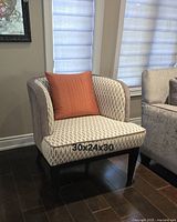 Full view of chair beside sofa, shows fabric pattern, legs, overall form