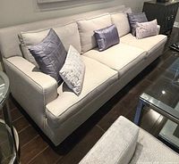 Full view of the light grey 3-seat sofa with cushions