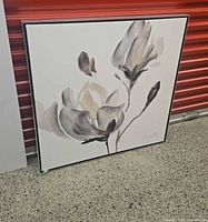 Full view of framed magnolia canvas resting against wall