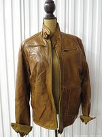 Full front view of tan leather bomber jacket on mannequin