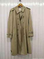 Front full view of khaki trench coat on hanger
