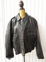 Front view of black leather motorcycle bomber jacket on dress form