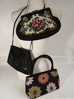 All three handbags displayed together on mannequin