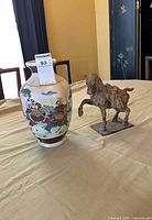 Vase and horse statue on table