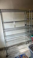 Full view of chrome wire shelving unit with six shelves and casters