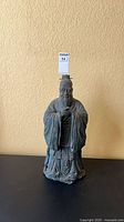 Front view of cast metal robed figurine