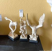 Three figurines side by side on surface