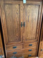 Front view showing paneled doors and four drawers