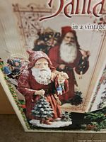 Box showing vintage-style Santa with tree and doll