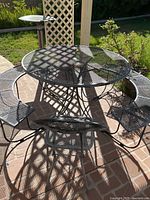 Full view of round metal table, attached benches, and separate chair